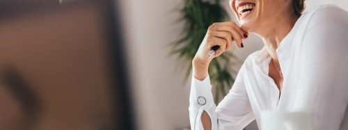 Smiling,Woman,Sitting,At,Her,Desk,In,Office.,Happy,Business